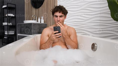 Caucasian man naked male guy relaxing in bath with soapy foam relax