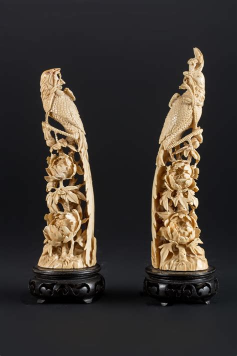 A Pair Of Ivory Carvings Depicting Birds Of Paradise On Ebony Stand