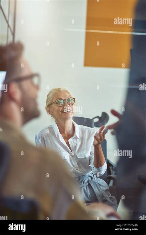 Cheerful Mature Business Woman Discussing Something With Colleagues And