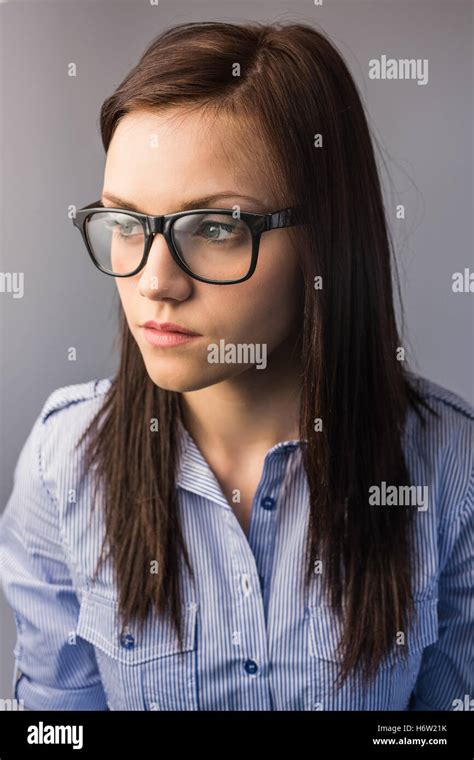 Thoughtful Pretty Brunette Wearing Glasses Posing On Grey Background Stock Photo Alamy