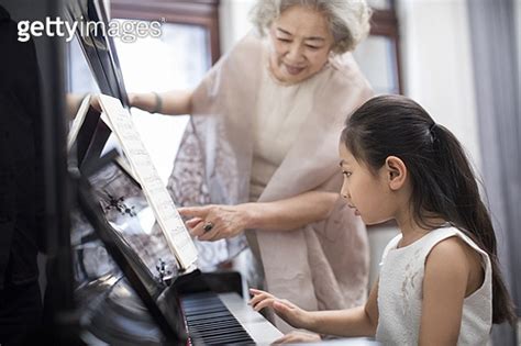 Grandmother teaching granddaughter to play the piano a11365262 게티이미지뱅크