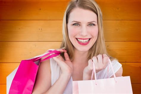 Premium Photo Portrait Of A Smiling Blonde Woman Holding Shopping