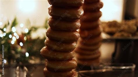 Vidéo Stock Festive Desserts with Stacked Glazed Donuts on Display at