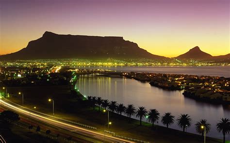 Silhouette Of Mountain Near City And Body Of Water During Sunset Hd