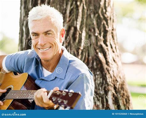 Hombre Mayor Que Maneja La Guitarra Al Aire Libre Foto De Archivo