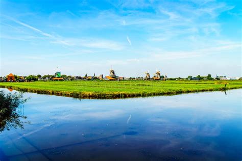 Typical Dutch Landscape With Open Fields Canals And Dutch Windmill