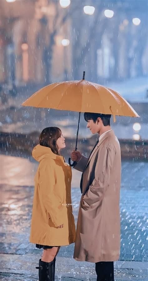 Two People Standing Under An Umbrella In The Rain