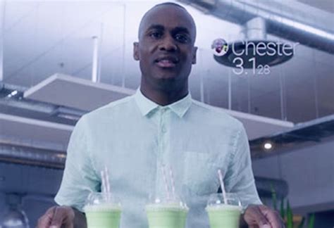 A Man Holding Three Green Smoothies In Front Of Him