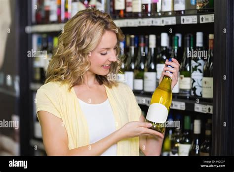 Smiling Pretty Blonde Woman Showing A Wine Bottle Stock Photo Alamy