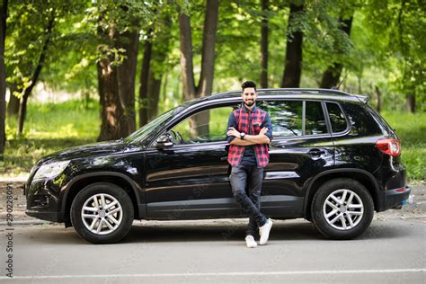 Young Handsome Indian Man Standing Near His Car On The Road Stock Photo