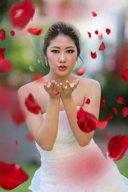 Premium Photo | Portrait of bride blowing red petals during wedding ...