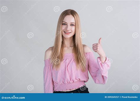 Portrait Of A Blonde Girl Who Shows Thumbs Up In The Studio On A White Background Stock Image