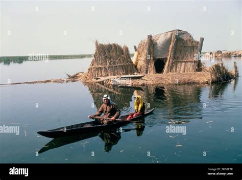 Marsh Arabs Southern Iraq. Marsh Arab man with daughter in boats with traditional reed built ...