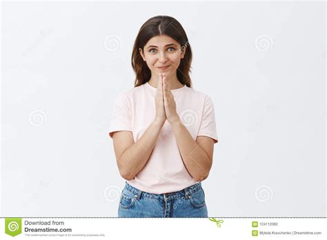 Studio Shot Of Cute Feminine Woman Being Grateful And Hopeful Holding