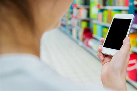 Photo Libre De Droit De À Laide De Smartphone Dans Un Supermarché