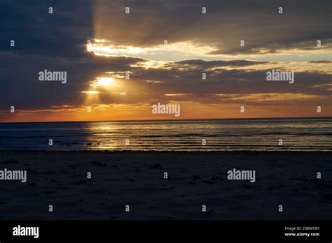 Colorful Ocean Beach Sunrise With Deep Blue Sky And Sun Rays Stock