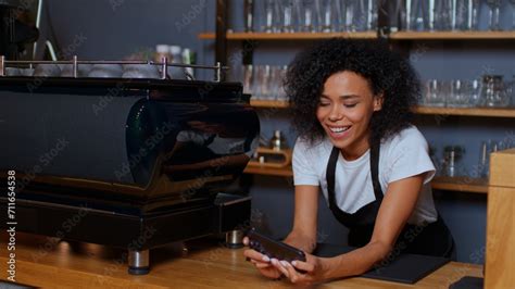 Dark Skinned Beautiful Woman Plays Games On Her Phone While Working