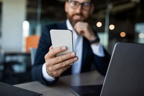 Empresario De Mediana Edad Sentado En El Escritorio Y Sosteniendo El