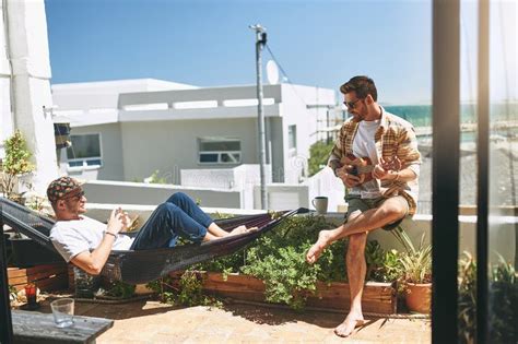 Gay Men And Playing Guitar By Home For Music Favorite Song And