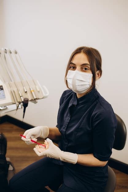 Mujer Dentista Con Guantes Que Muestra En Un Modelo De Mandíbula Cómo Limpiar Los Dientes Con El