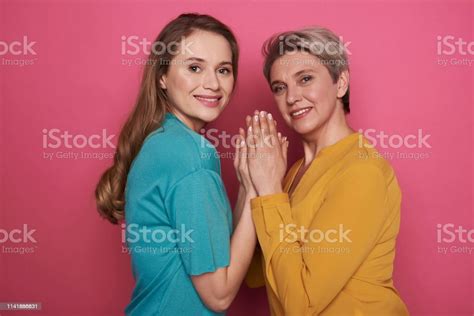 Smiling Mother And Daughter Holding With Hands While Looking At Camera