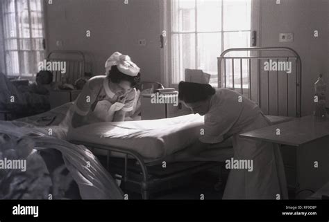 1950s Historical Two Female Nurses In A Hospital Ward Putting New