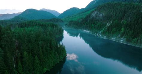 Aerial View Of Elbow Lake And Mountains In Spring Fog Creeps Over The