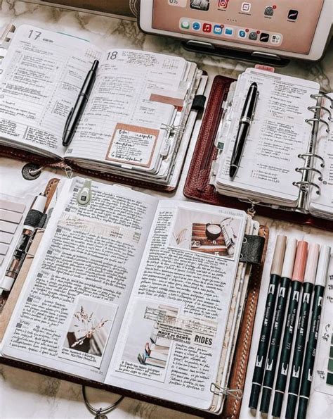 Several Notebooks And Pens Sitting On Top Of A Table Next To A Laptop