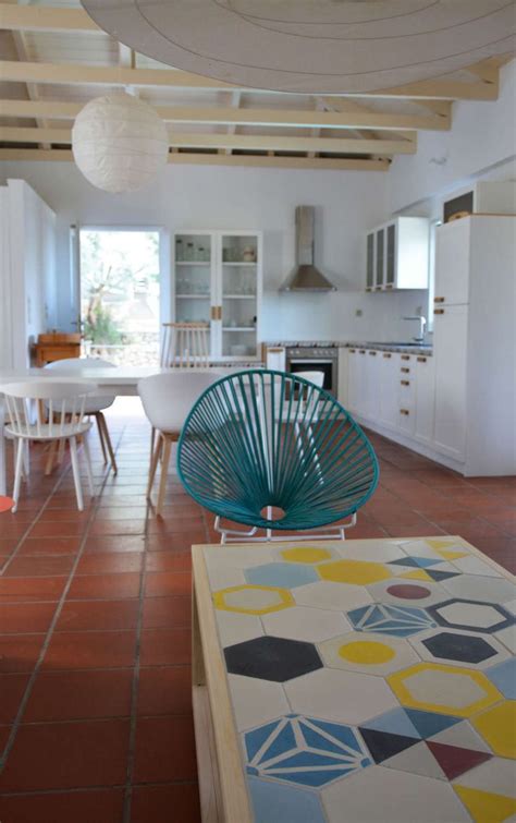 An Open Kitchen And Dining Room With Tile Flooring White Walls And