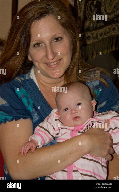 Older Mother Holding Her New Baby Who Was Born With Down Syndrome