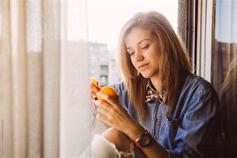 Blonde Girl Peeling An Orange By Stocksy Contributor Boris Jovanovic Stocksy