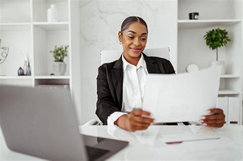 Premium Photo | Happy black female entrepreneur reading business papers ...