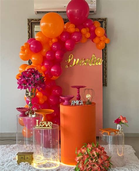 An Orange And Pink Party With Balloons On The Wall Flowers In Vases