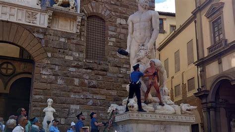 Un uomo nudo si è arrampicato sulla statua in Piazza della Signoria a