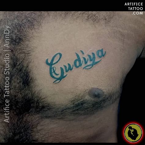 a man with a tattoo on his chest has the word kudiya written in cursive ink