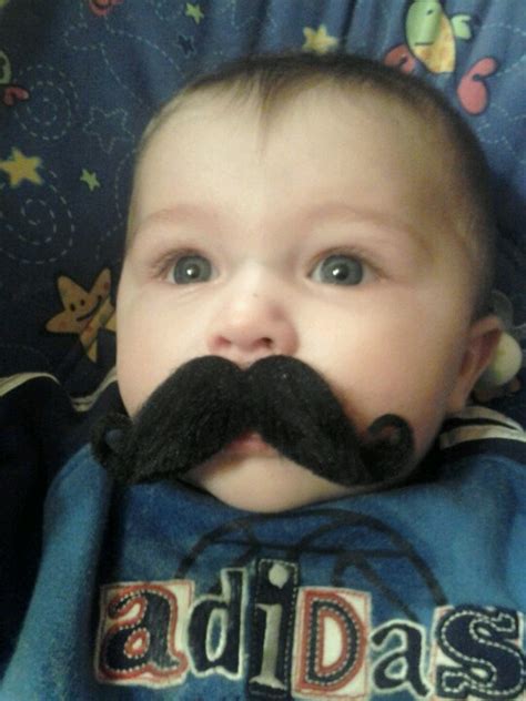 A Baby With A Fake Moustache On His Face