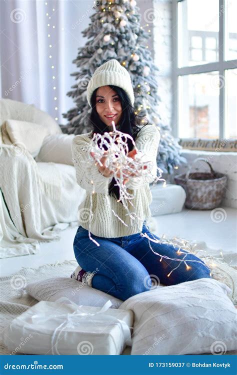 Brunette Girl In Sweater And Jeans In Front Of Her Christmas Tree Stock Image Image Of Elegant