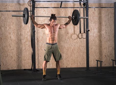 Barra De Levantamento Forte Do Homem Novo Peso No Gym Foto De Stock