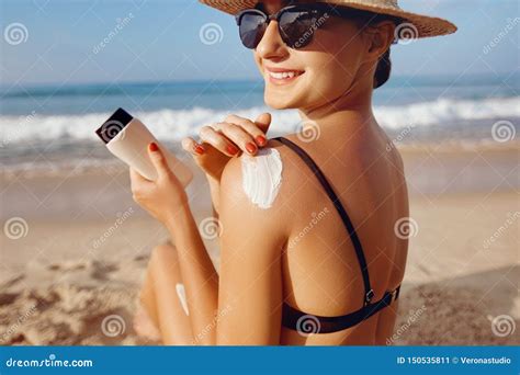 Beautiful Woman In Bikini Applying Sun Cream On Tanned Shoulder Sun