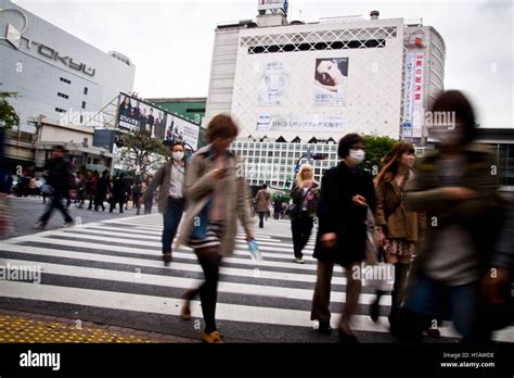 People Cross A Zebra Crossing In The Shinjuku Area Of Tokyo Japan