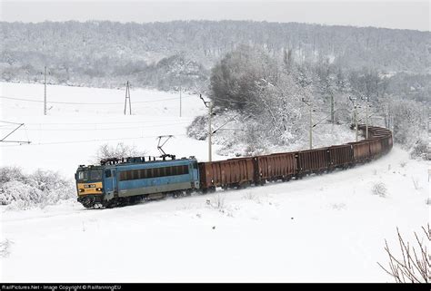 A Train Is Traveling Down The Tracks In The Snow