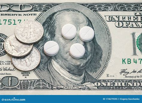 Small Coins On A Banknote Of One Hundred Dollars White Tablets Lie On