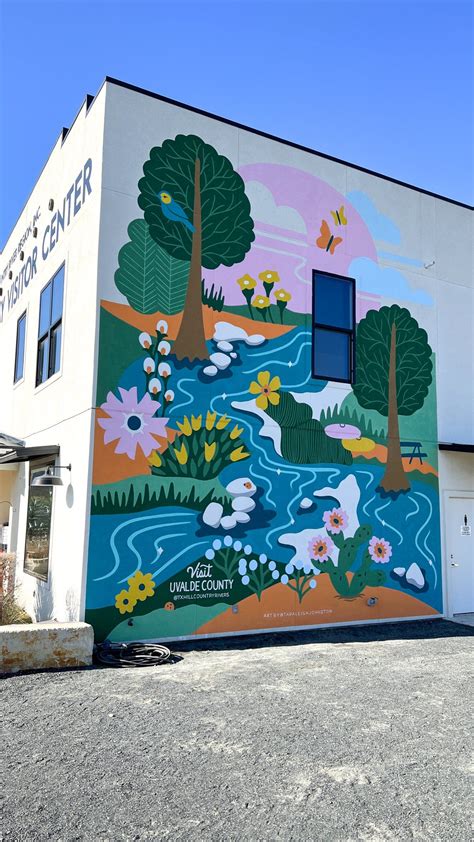 A Large Mural On The Side Of A Building With Trees And Flowers Painted