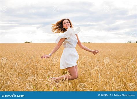 Happy Woman Jumping In Field Against Blue Sky Vacation And Freedom