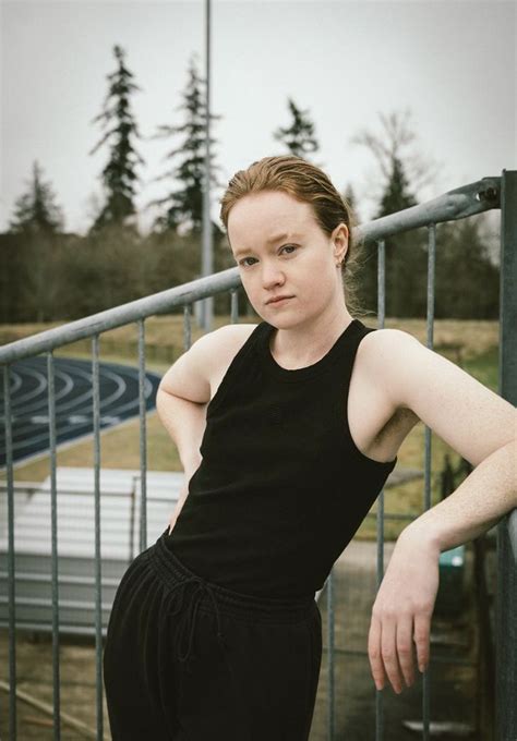 A Woman Leaning Against A Rail With Her Hands On Her Hips