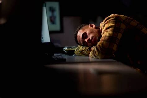 Businessman Working Late In Office Sleeping At Desk Stock Image