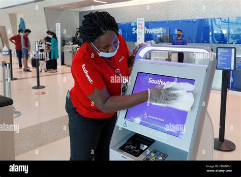 Southwest Airlines employee La Toya Malone Key wipes down a kiosk after ...