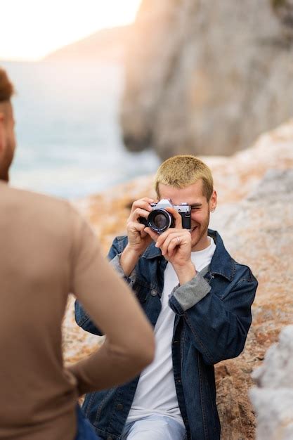 Couple gay sur la plage avec caméra Photo Gratuite