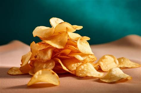 Premium Photo Piled Of Crispy Potato Chips Against Dark Background