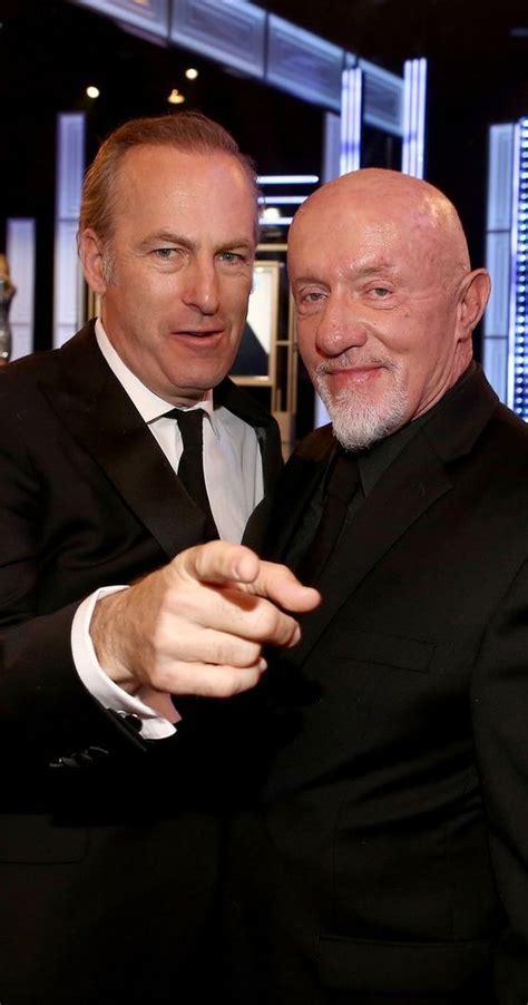 Two Men In Tuxedos Are Posing For The Camera With One Pointing His Finger